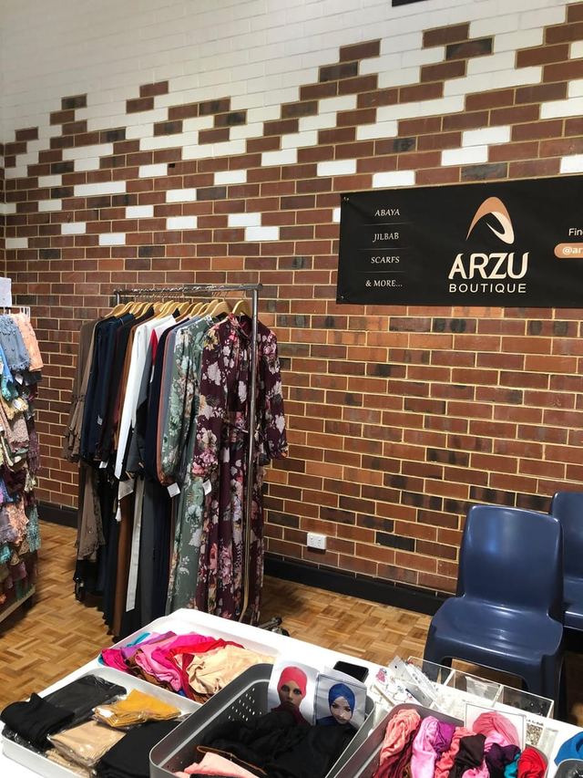 Hijabs and abayas on a golden rack at a modest fashion stall, Urban Pop Ups Perth