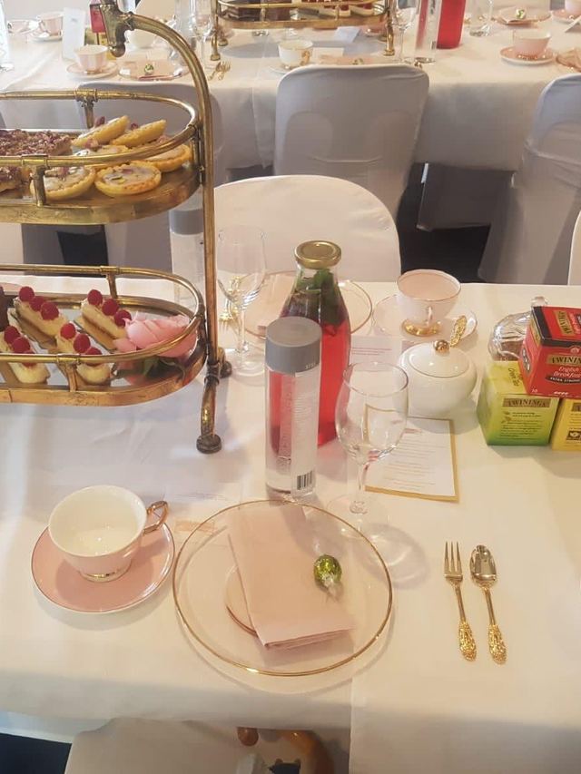 Gold tiered stand of scones and eclairs on a pink and white table at an Urban Pop Ups ladies high tea