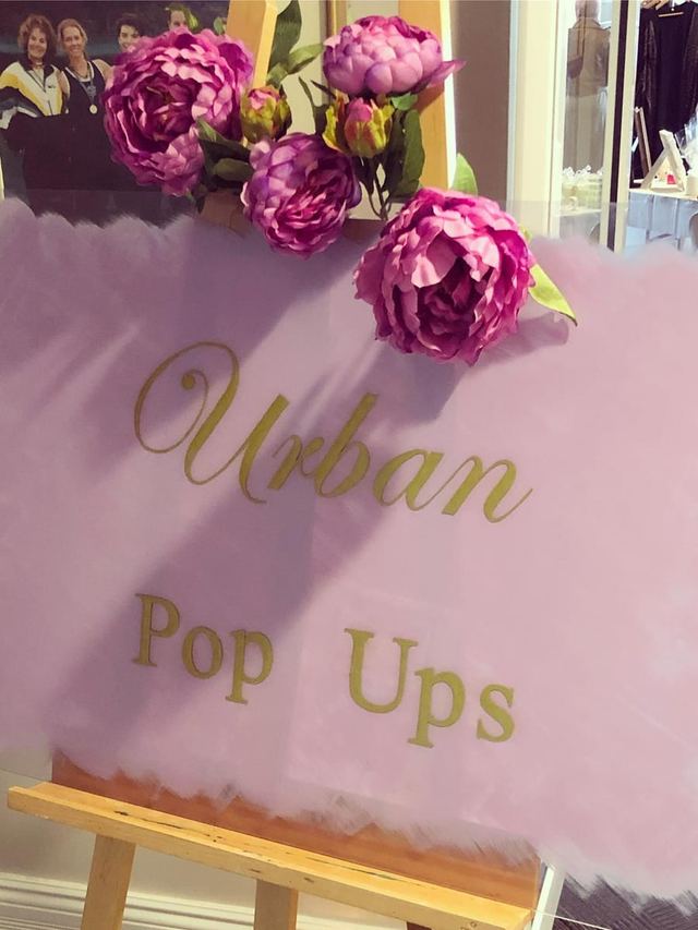 Urban Pop Ups easel sign in gold lettering on pink tulle with peonies at a Perth market